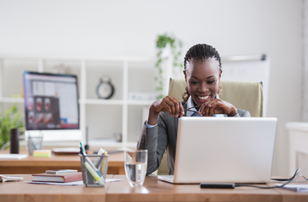 Woman veteran looking happy at a laptop screen